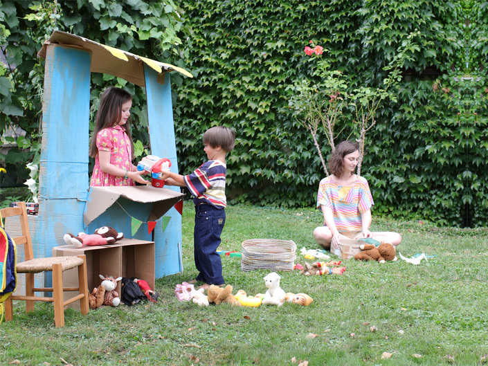 Enfants en train de jouer à la marchande dans un jardin