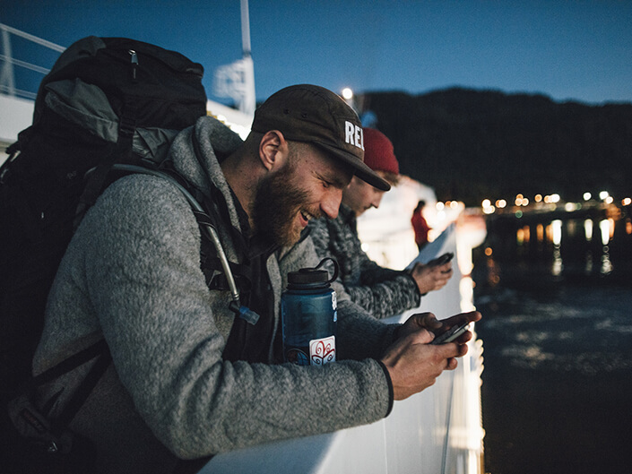 Deux hommes voyageant sur un bateau naviguent sur leurs téléphones